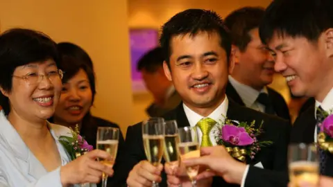 Getty Images Anta chairman Ding Shizhong clinking glasses with guests at the company's listing ceremony in 2007.